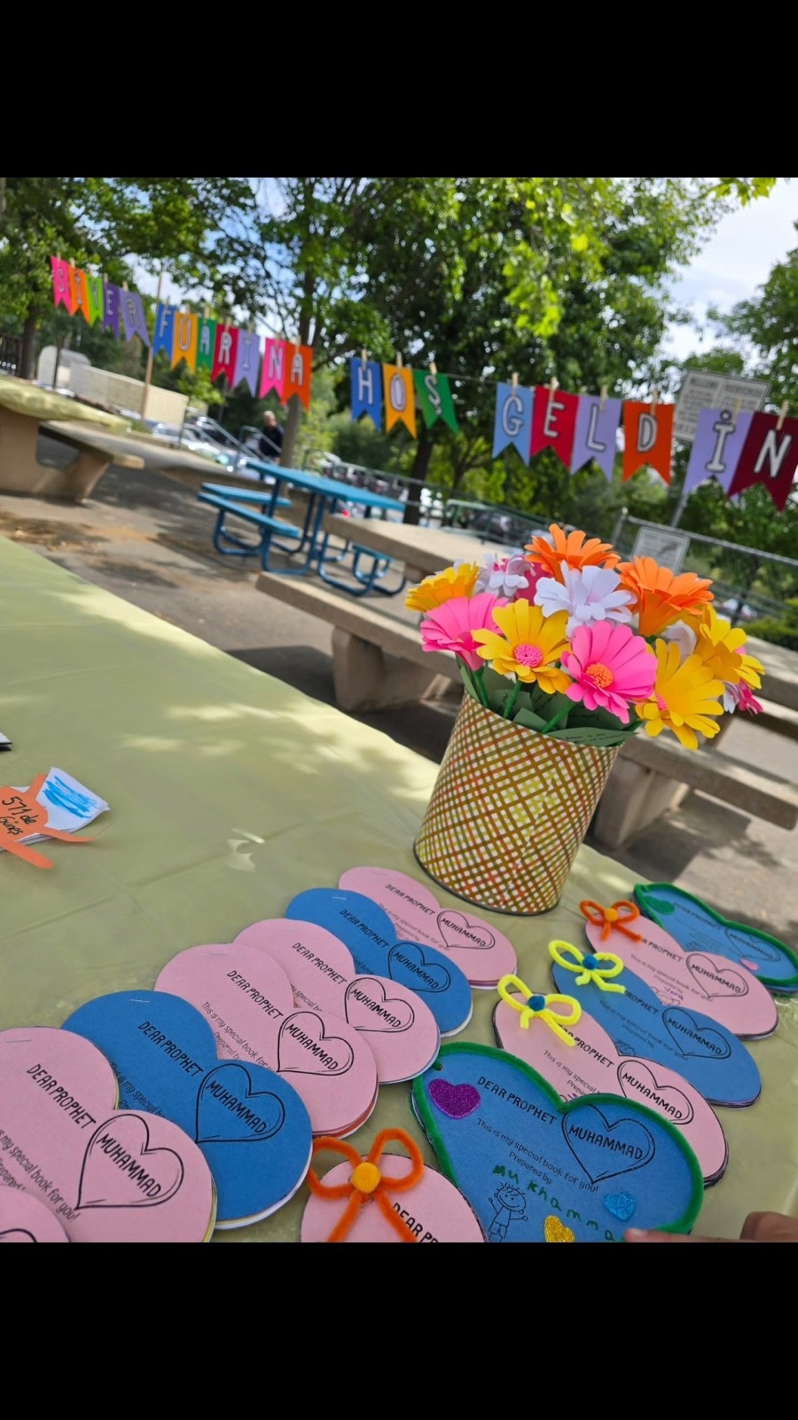 Heart-shaped Seerah project booklets on a table with paper flowers