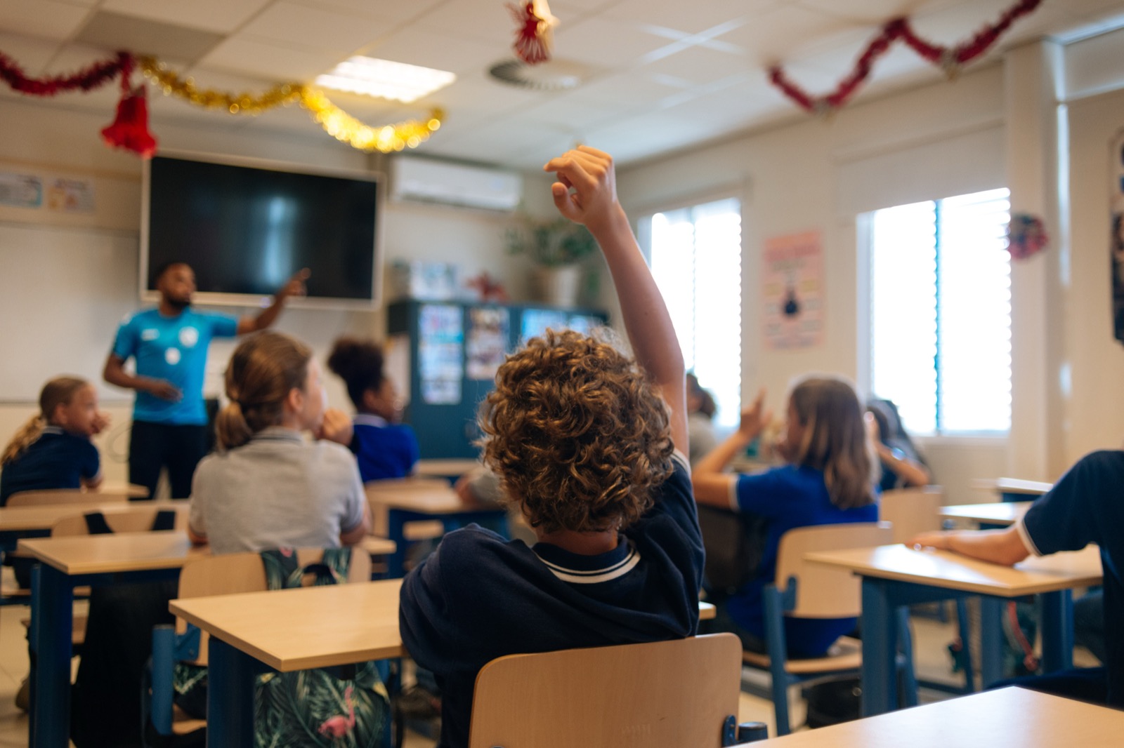 Students raising their hands in a classroom